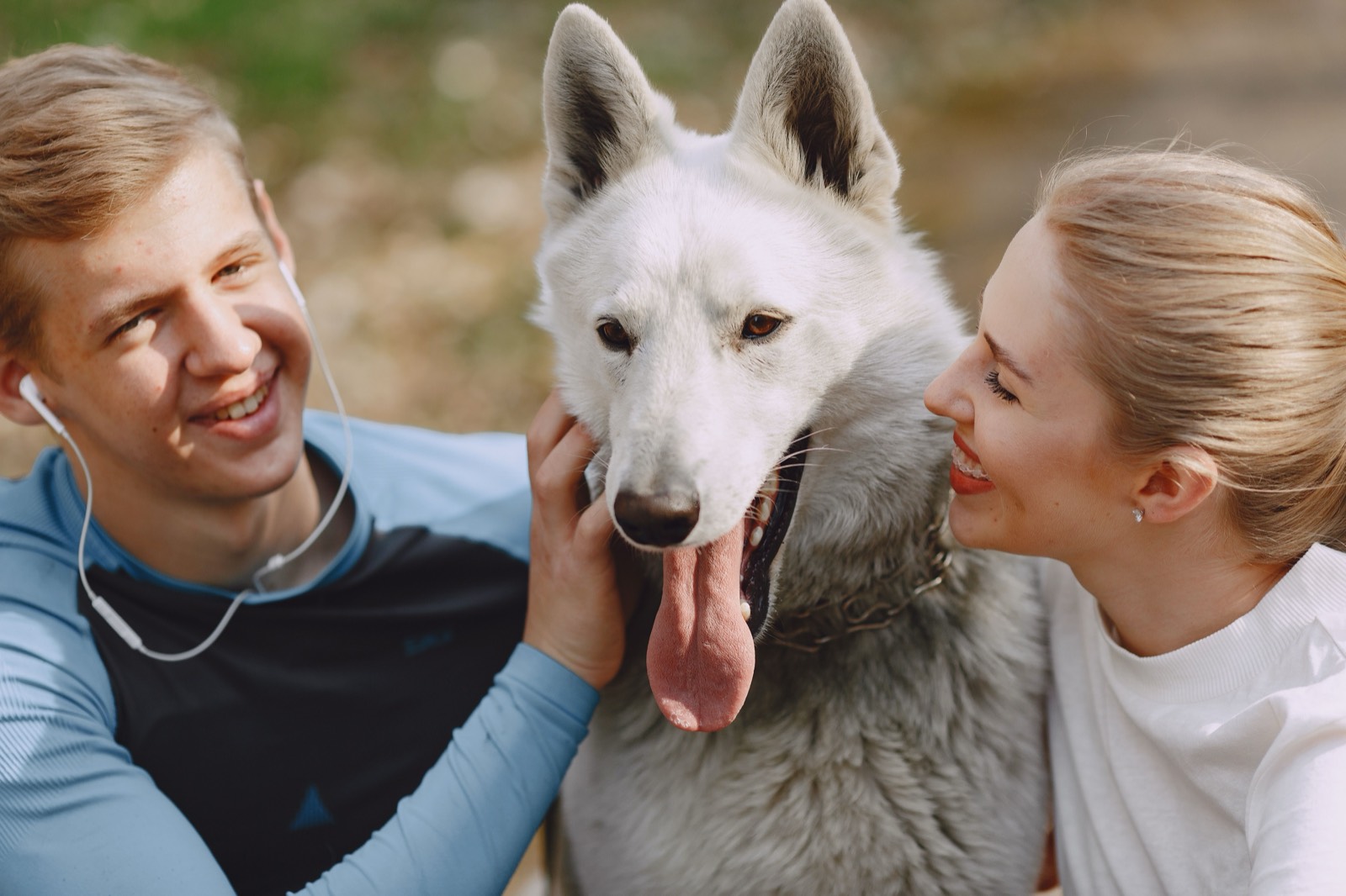 Man and woman outdoors with a large white dog
